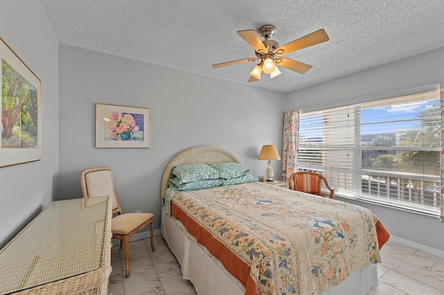 bedroom featuring ceiling fan and a textured ceiling