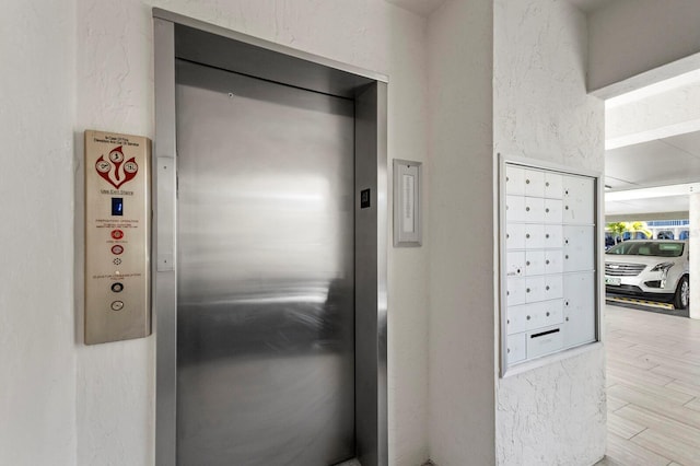 room details with hardwood / wood-style floors, a mail area, and elevator