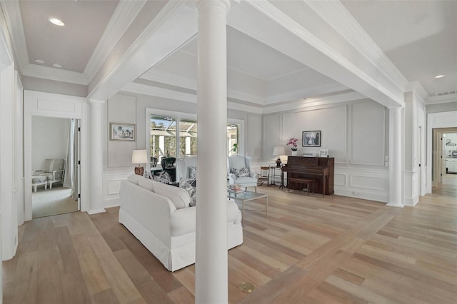 living room featuring decorative columns and crown molding