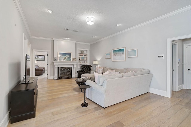 living room with light hardwood / wood-style floors, built in features, a textured ceiling, and ornamental molding