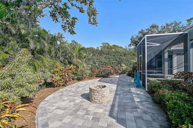 view of patio with glass enclosure and an outdoor fire pit