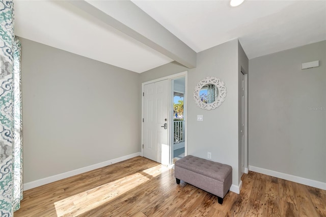 foyer with beam ceiling and light wood-type flooring