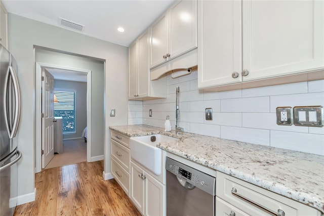 kitchen featuring white cabinetry, light wood-type flooring, and appliances with stainless steel finishes