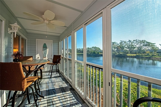 sunroom with ceiling fan, a water view, and a healthy amount of sunlight