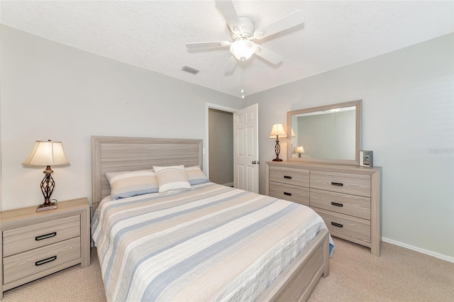 carpeted bedroom featuring ceiling fan and a textured ceiling