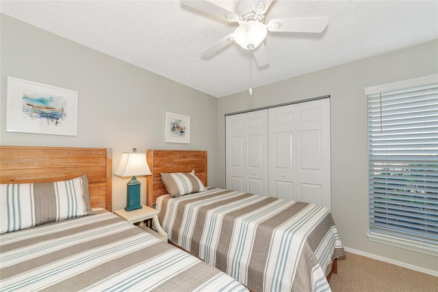 bedroom featuring ceiling fan, a closet, carpet floors, and a textured ceiling