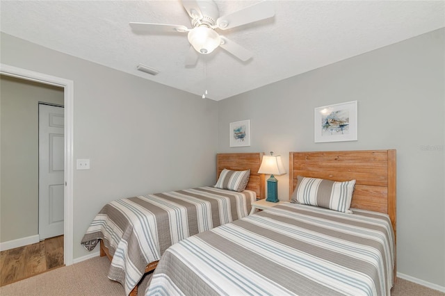 bedroom featuring ceiling fan, carpet floors, and a textured ceiling