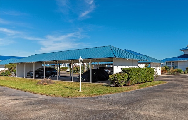 view of car parking featuring a carport and a lawn