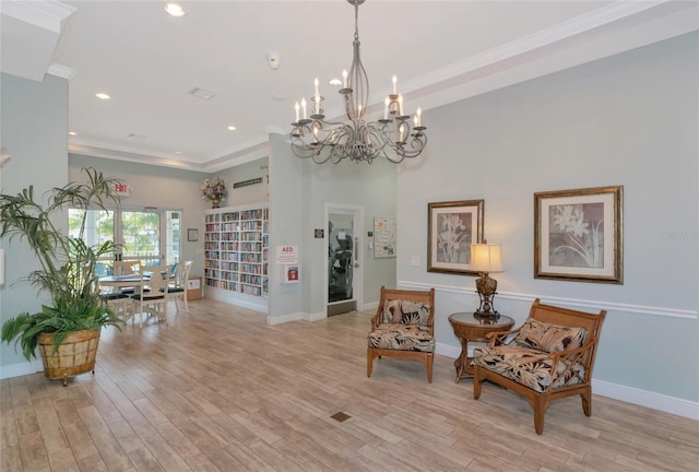 living area with light wood-type flooring, crown molding, and an inviting chandelier