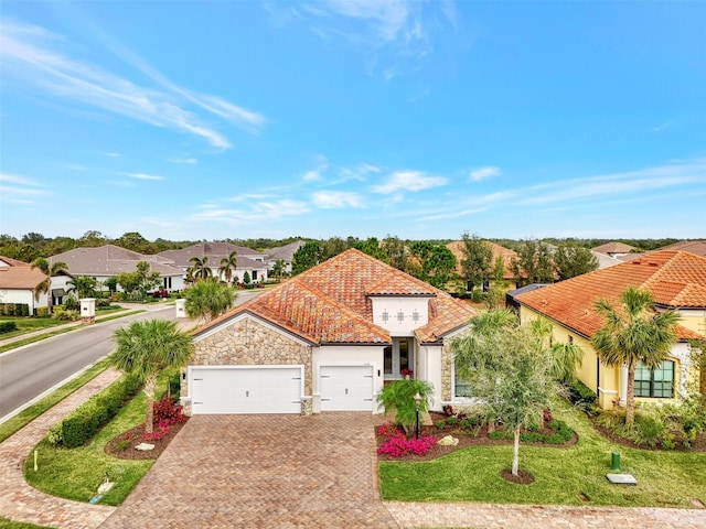 mediterranean / spanish home featuring a front yard and a garage