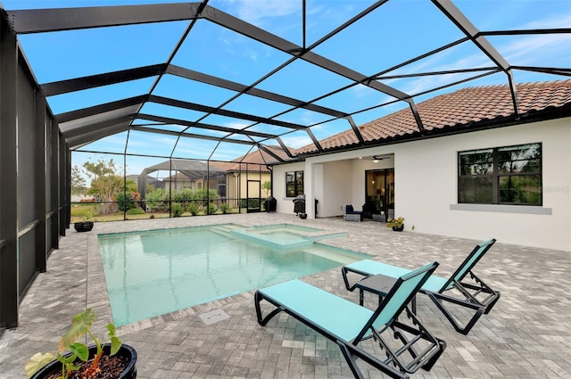 view of pool with glass enclosure, ceiling fan, and a patio