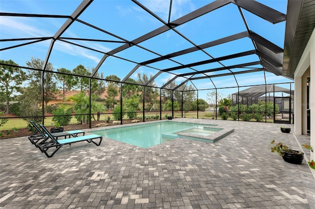 view of swimming pool with glass enclosure, an in ground hot tub, and a patio