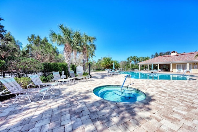 view of swimming pool with a patio and a hot tub