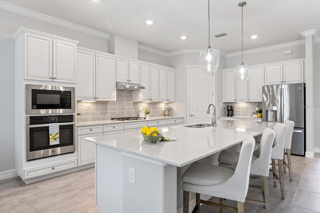 kitchen featuring visible vents, appliances with stainless steel finishes, under cabinet range hood, white cabinetry, and a sink