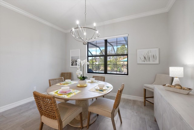 dining space featuring light wood-type flooring, a notable chandelier, crown molding, and baseboards