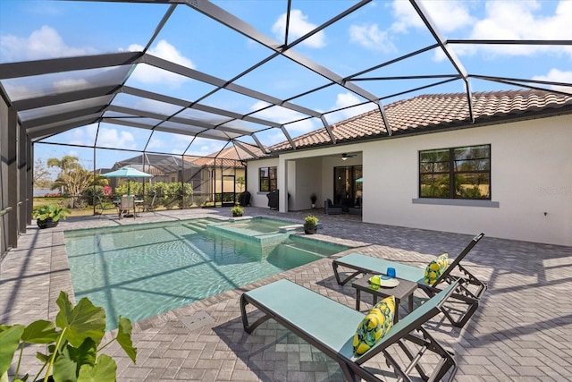 view of swimming pool featuring glass enclosure, a pool with connected hot tub, ceiling fan, and a patio