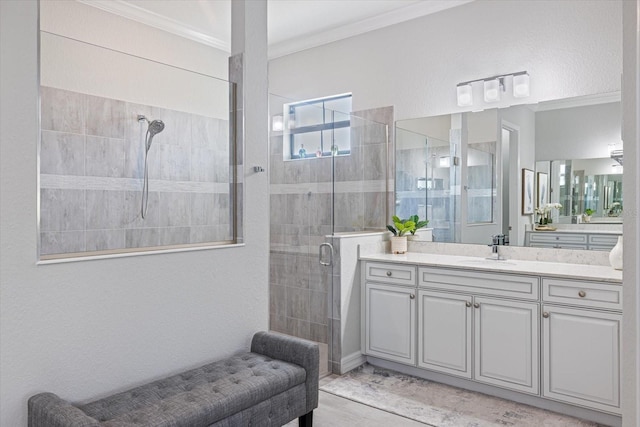 full bathroom featuring a stall shower, crown molding, and vanity