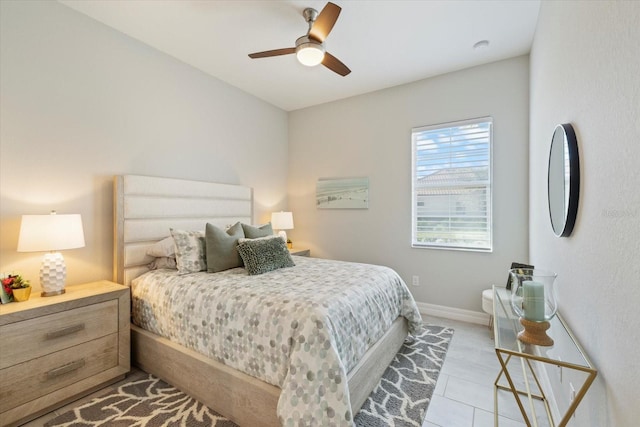 bedroom with ceiling fan, baseboards, and light tile patterned floors