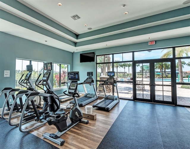 gym with french doors, visible vents, baseboards, and wood finished floors