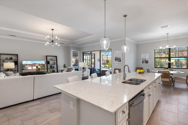 kitchen featuring dishwasher, open floor plan, a sink, and an inviting chandelier