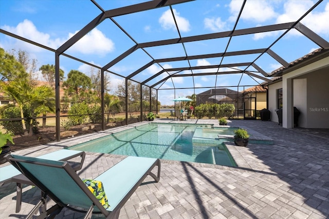 view of pool with a lanai, a patio area, and a pool with connected hot tub