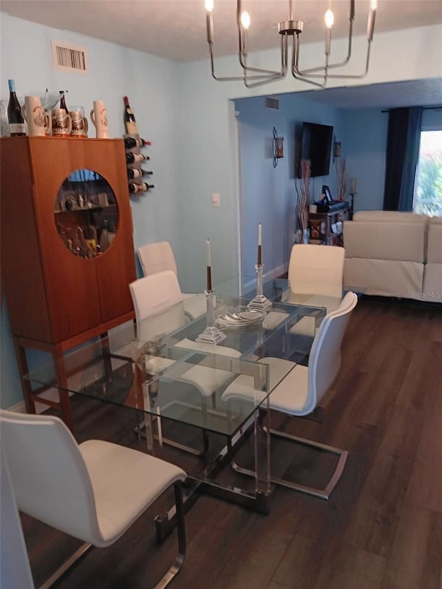 dining space with hardwood / wood-style flooring and a notable chandelier