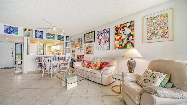 living room featuring a textured ceiling, light tile patterned flooring, and track lighting