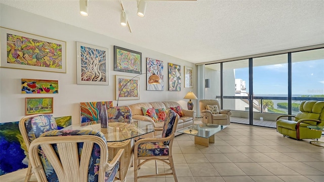 tiled living room with floor to ceiling windows and a textured ceiling