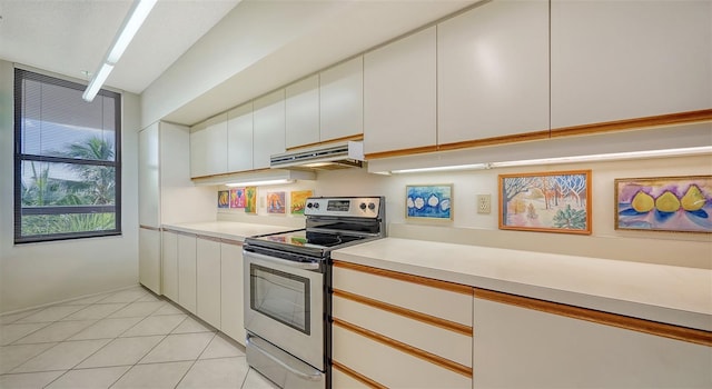 kitchen featuring stainless steel electric range oven, white cabinetry, and light tile patterned floors