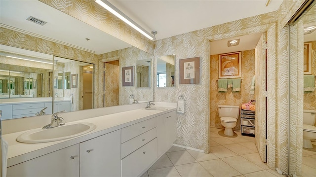 bathroom with toilet, tile patterned floors, and vanity