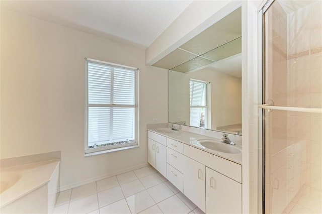 bathroom with a shower stall, double vanity, tile patterned floors, and a sink