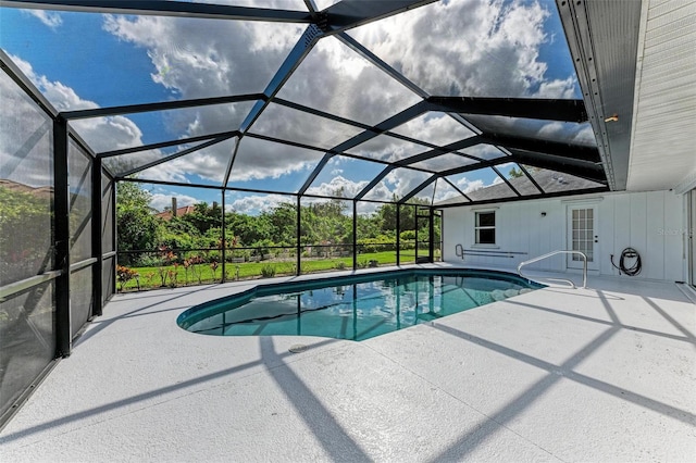 pool featuring glass enclosure and a patio area