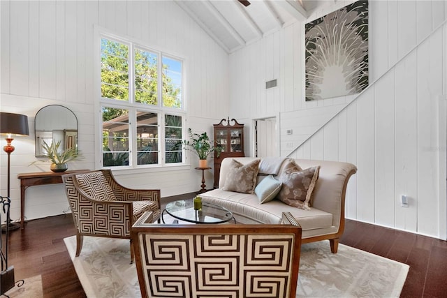 living area with beam ceiling, wood walls, high vaulted ceiling, and dark wood-type flooring