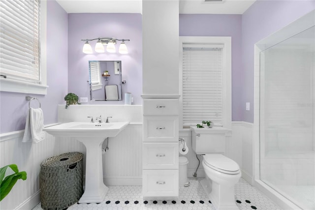 bathroom featuring tile patterned floors, a shower, and toilet