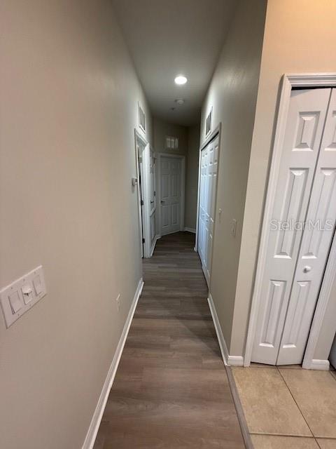 corridor with hardwood / wood-style flooring