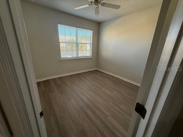 spare room featuring ceiling fan and dark hardwood / wood-style flooring