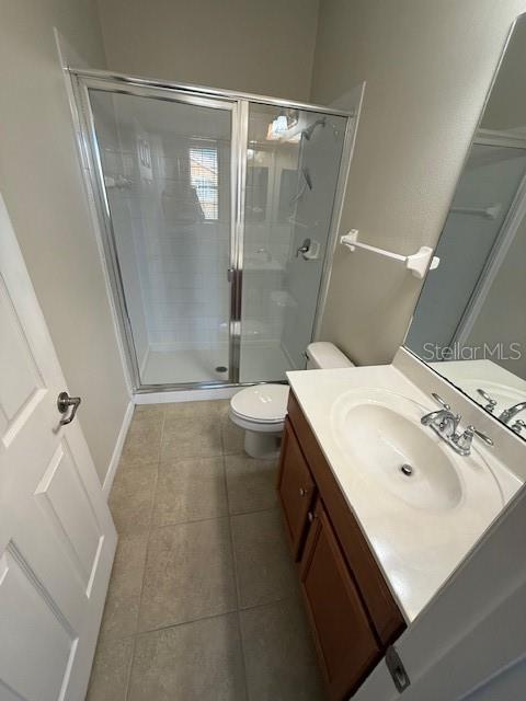 bathroom featuring an enclosed shower, tile patterned flooring, toilet, and vanity