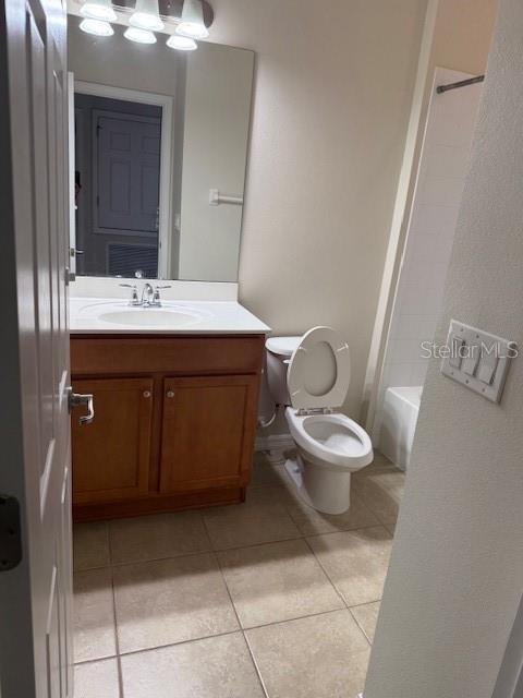 full bathroom with tile patterned floors, vanity,  shower combination, and toilet