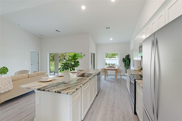 kitchen featuring sink, a center island, light hardwood / wood-style flooring, white cabinets, and appliances with stainless steel finishes