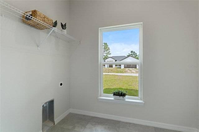 laundry area featuring electric dryer hookup, tile patterned floors, and a healthy amount of sunlight