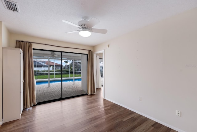 unfurnished room featuring ceiling fan, wood-type flooring, and a textured ceiling