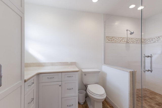 bathroom featuring toilet, walk in shower, and vanity