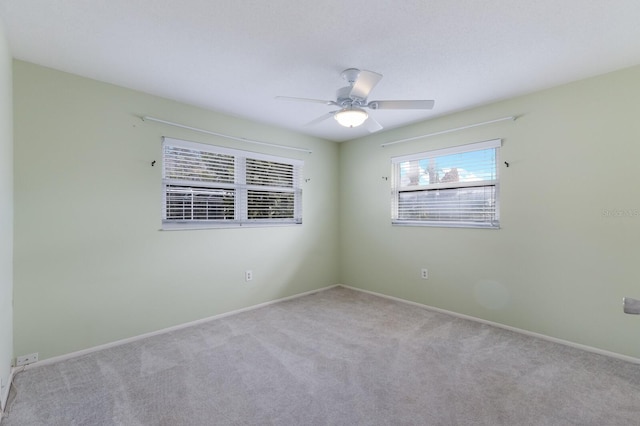 spare room with ceiling fan and light colored carpet