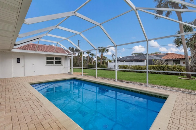 view of swimming pool with glass enclosure, a lawn, and a patio