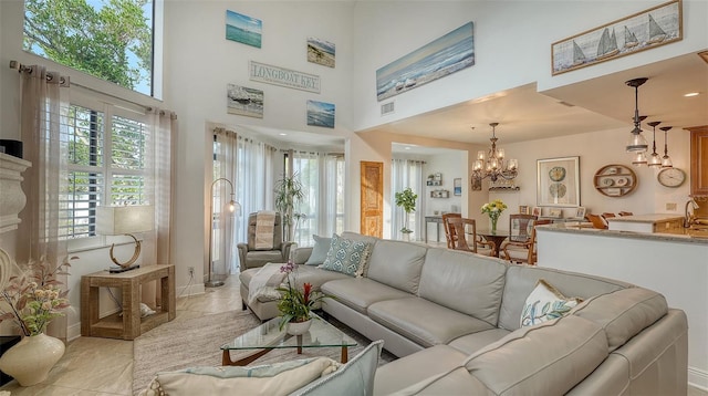 living room with a towering ceiling and an inviting chandelier