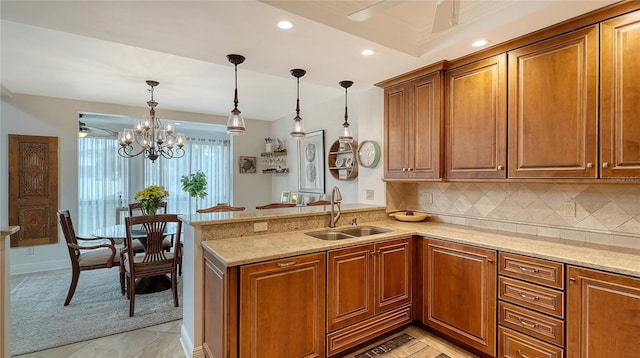 kitchen featuring decorative light fixtures, kitchen peninsula, and sink