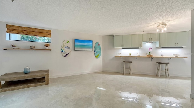 kitchen with kitchen peninsula, a textured ceiling, and a kitchen bar