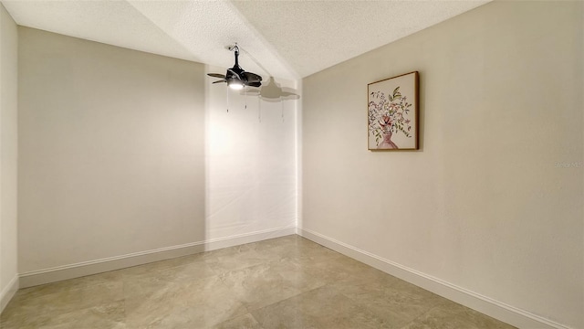 empty room featuring ceiling fan, a textured ceiling, and vaulted ceiling