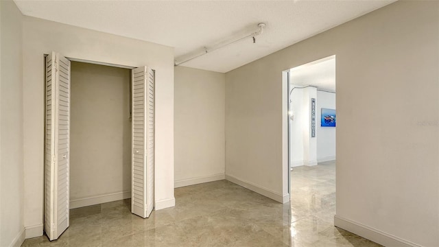 unfurnished bedroom featuring a textured ceiling and a closet