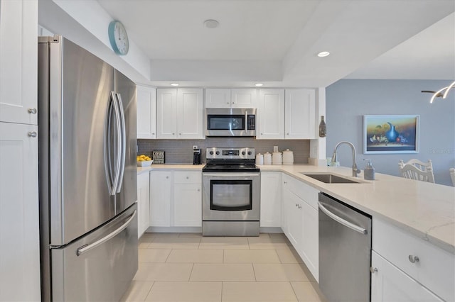 kitchen with light stone counters, white cabinetry, sink, and appliances with stainless steel finishes